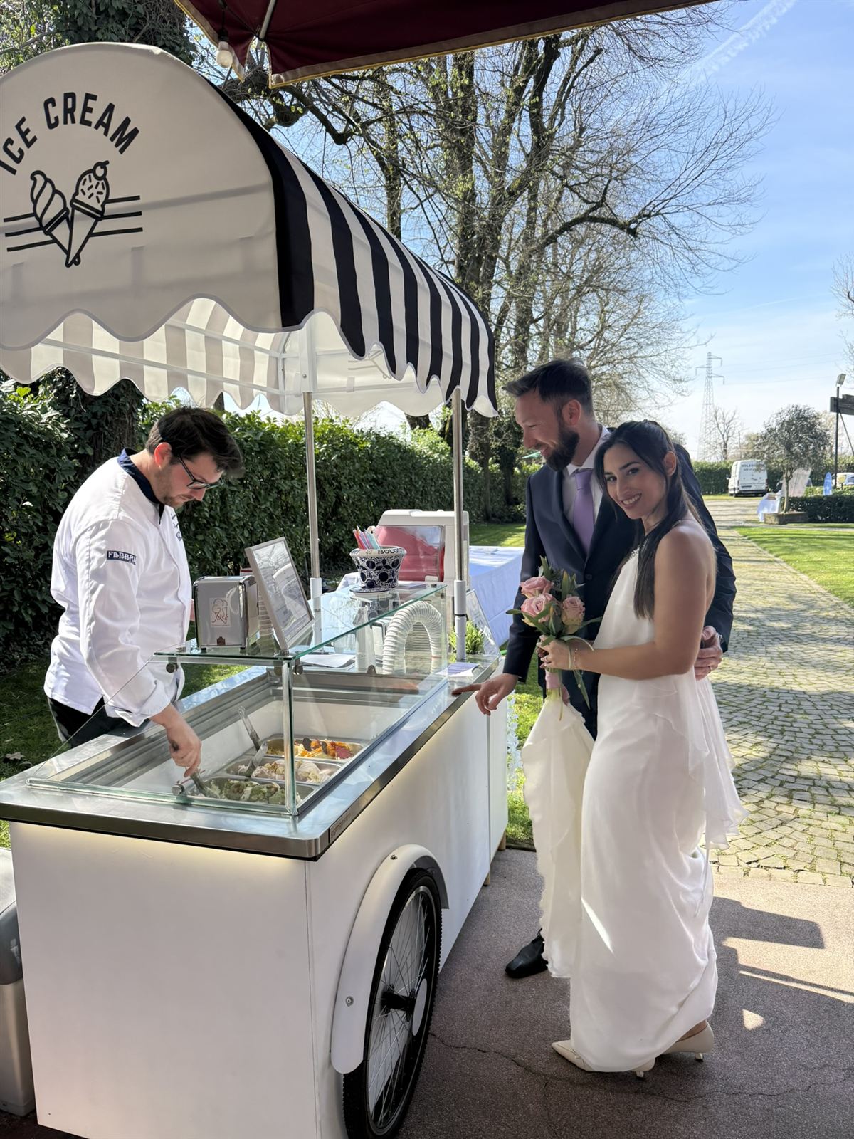 Il gelatiere serve il gelato agli sposi al carretto