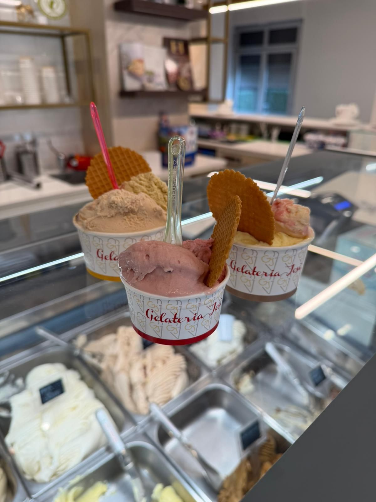Coppette di gelato con wafer davanti alla vetrina