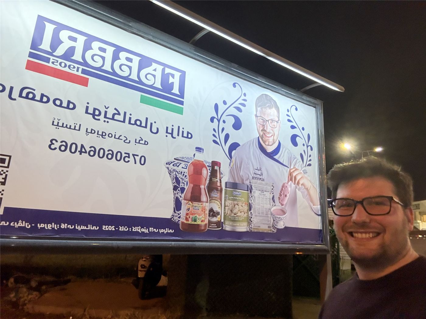 Stefano accanto a un enorme cartellone Fabbri con il suo volto
