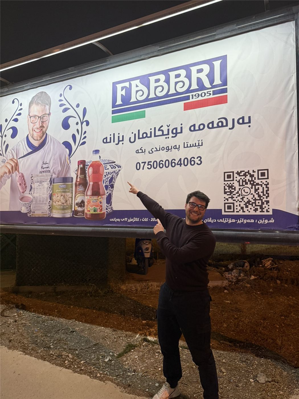 Stefano indica un cartellone Fabbri con la sua immagine